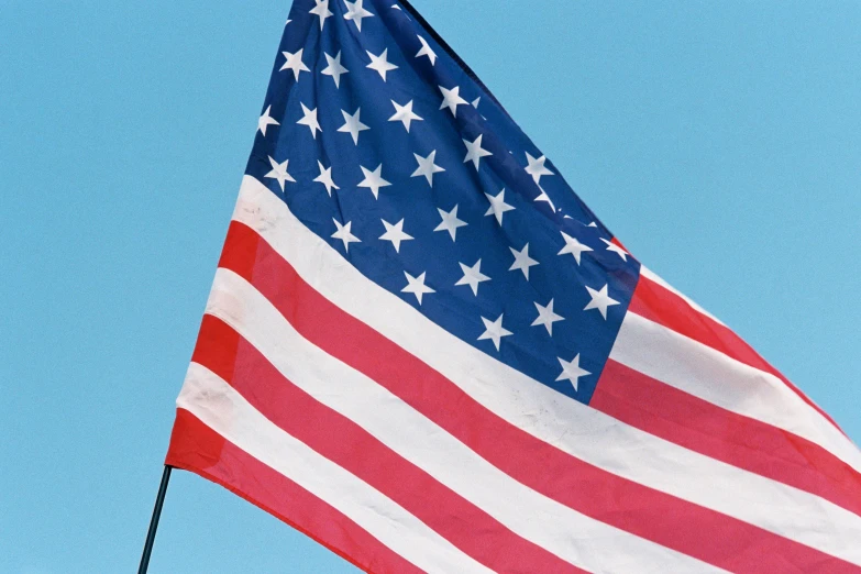 an american flag blowing in the wind on a clear day