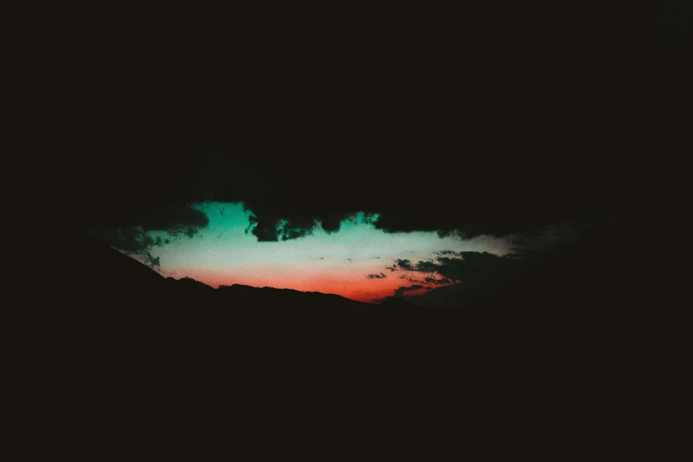 a view of a sunset with clouds and a green sky