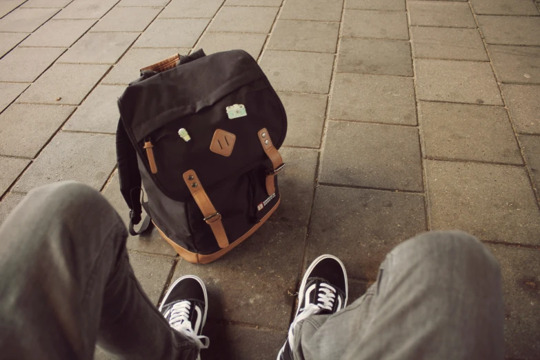 a person standing next to a backpack on the ground