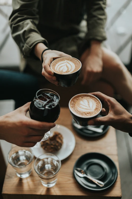 two couples are sharing coffee and drinking from their mugs