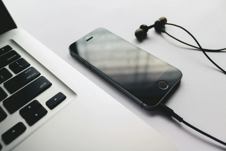 an ipod ear buds connected to a laptop computer