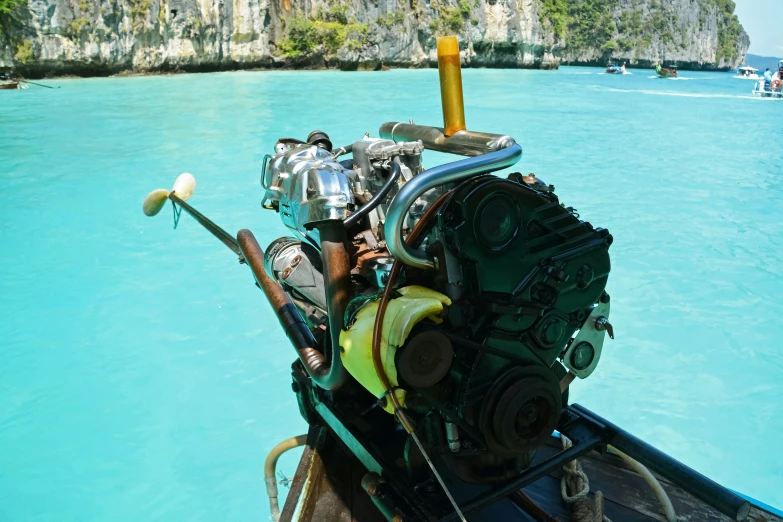 a small boat with an engine sits in clear water