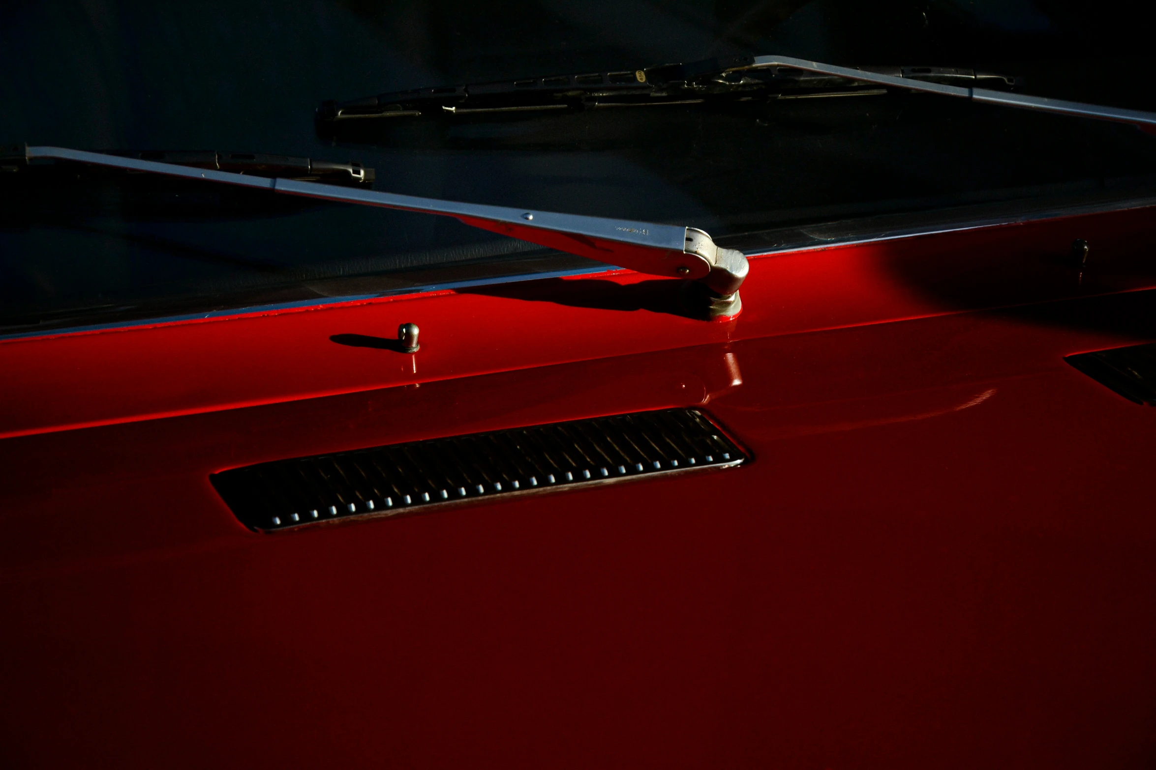 a dark red car's hood and window