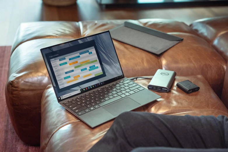 an open laptop computer sitting on top of a leather couch