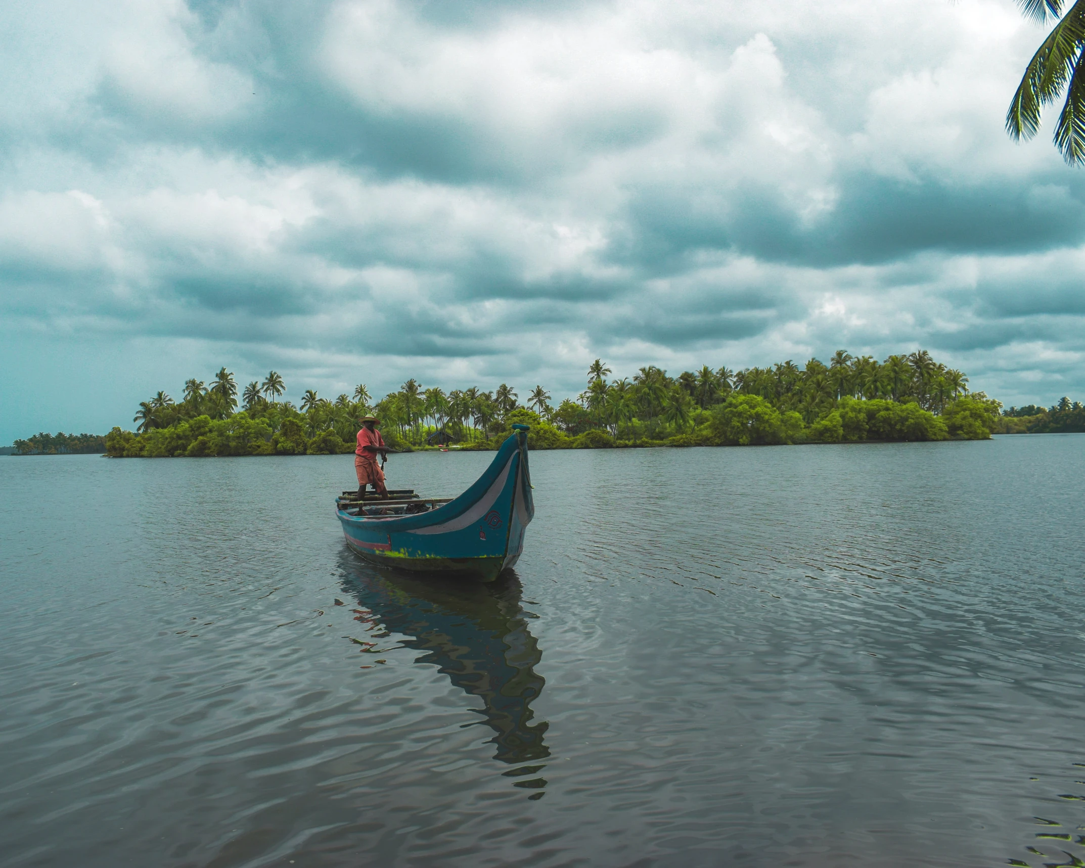 man in blue boat looking at the water