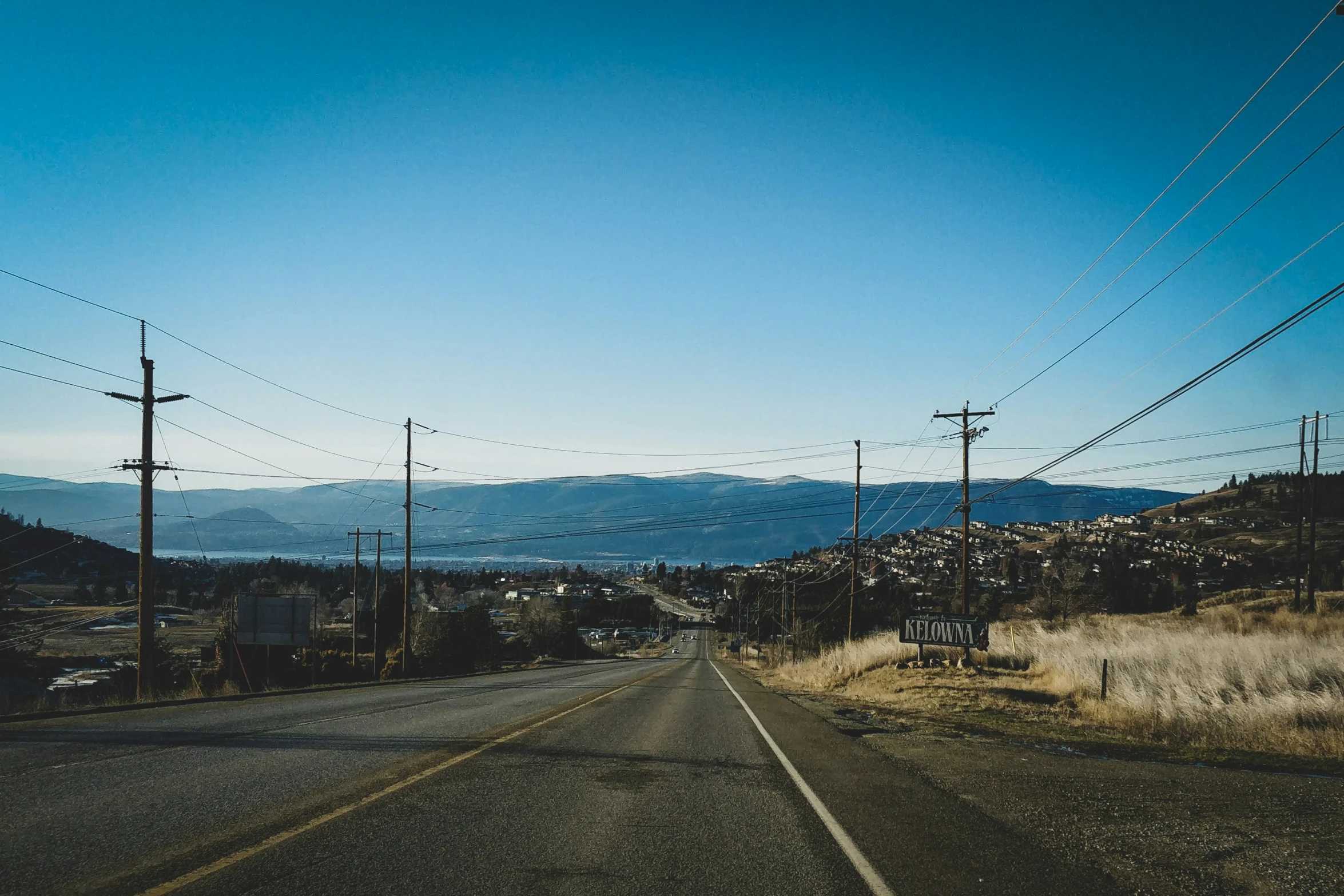 a scenic road leading through the mountains with telephone poles