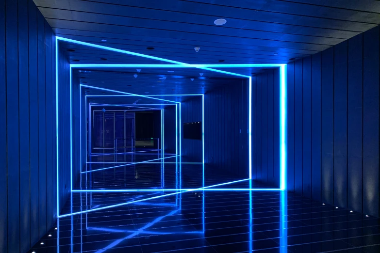 the inside of an empty building lit by blue neon lights