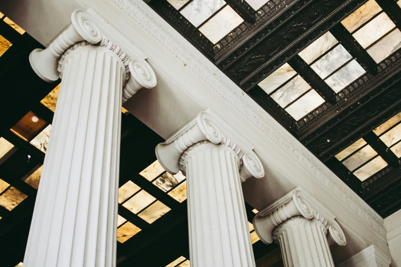 a bunch of very tall white columns near some buildings