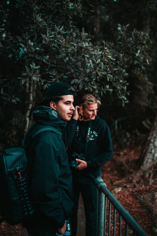 two guys on the stairs of a tree covered hill