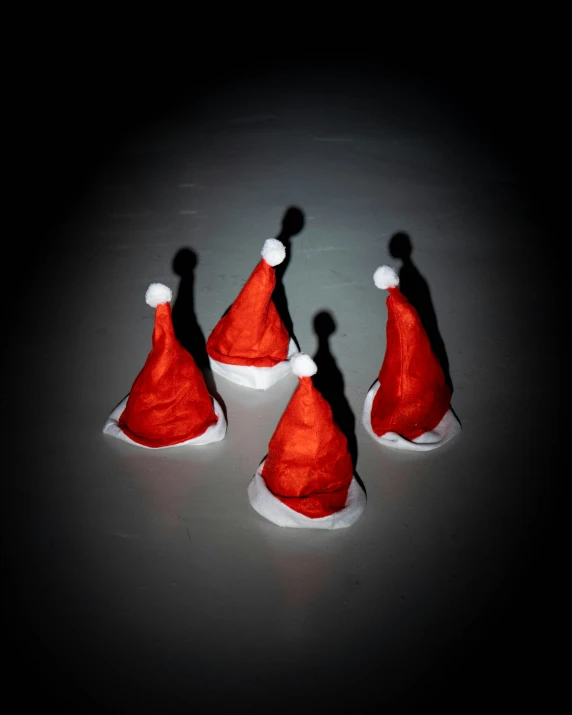 three little santa hats sit on a table