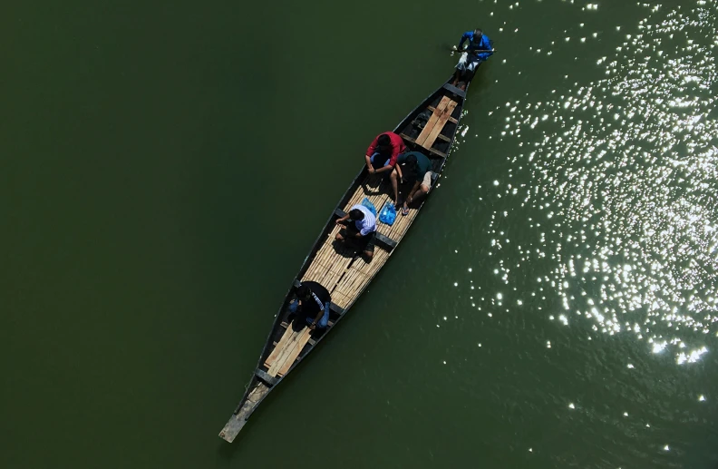 three people are in the boat floating on the water