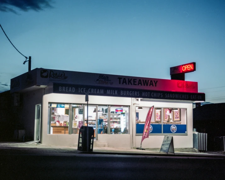 a takeaway shop is lit up at night