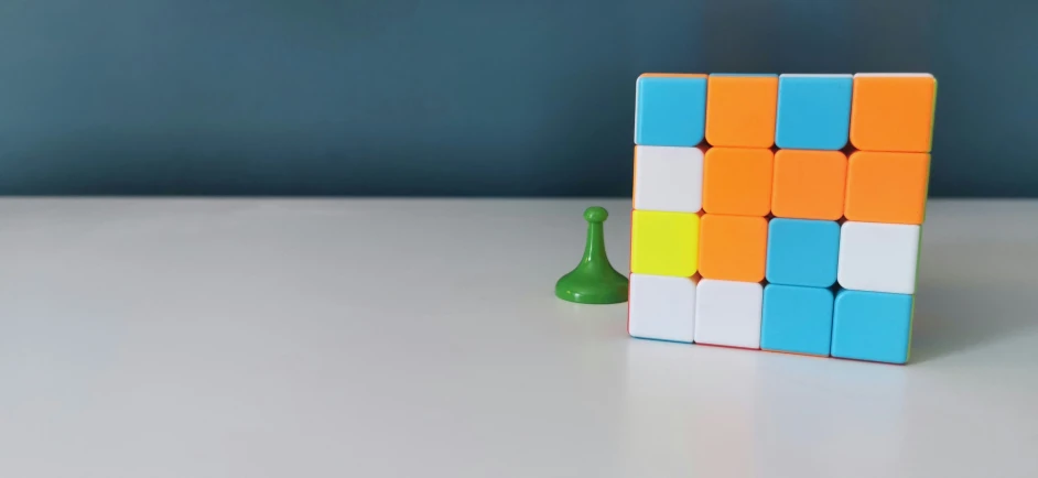 a small white and yellow cube with a green vase