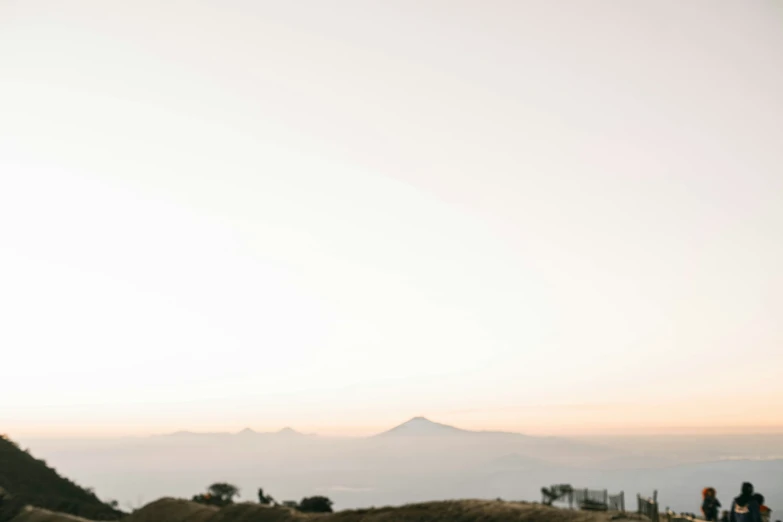 a man in glasses on a dirt path by mountains