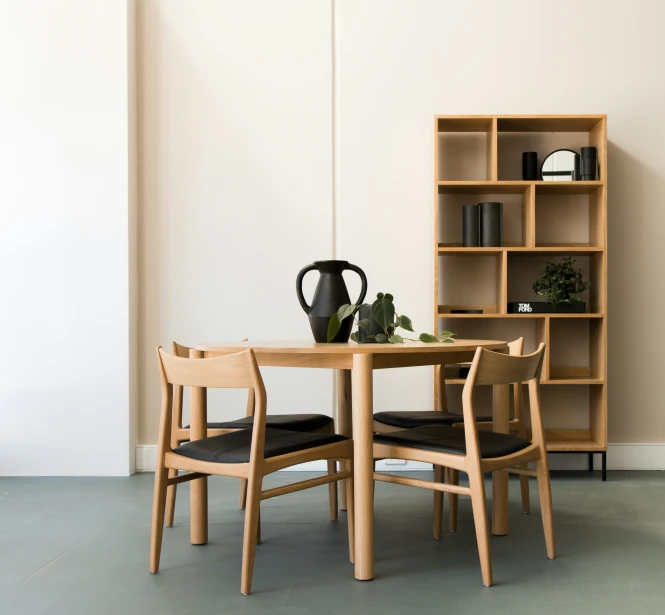 the modern dining room table has two black chairs
