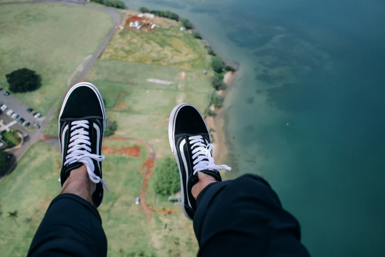 man in sneakers is on an aerial platform overlooking a river and land