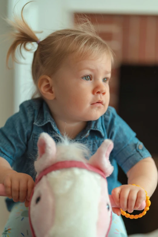 a little girl plays with her toy horse