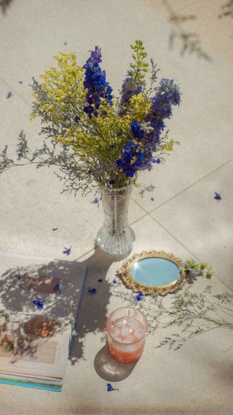 blue flowers in a vase sitting on the ground