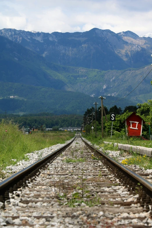 the train tracks lead down to a mountain range