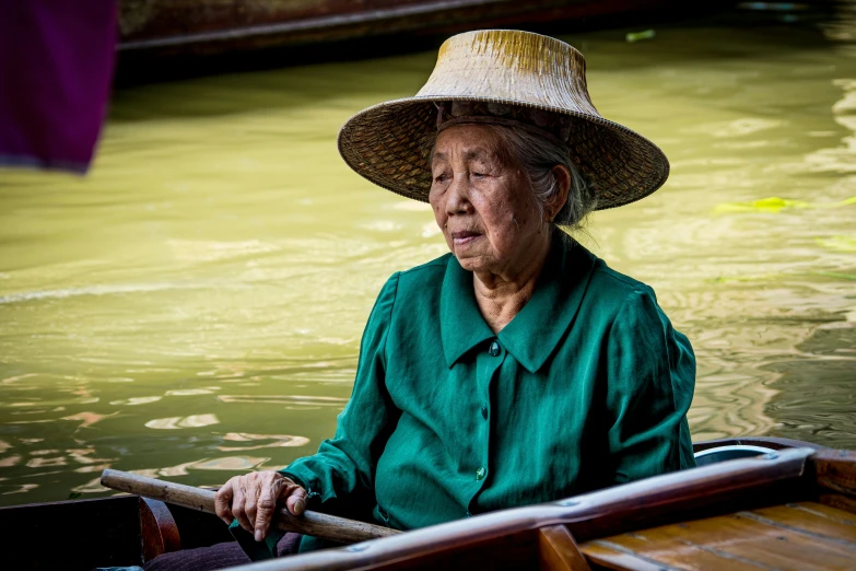 a woman in a straw hat floating down a river