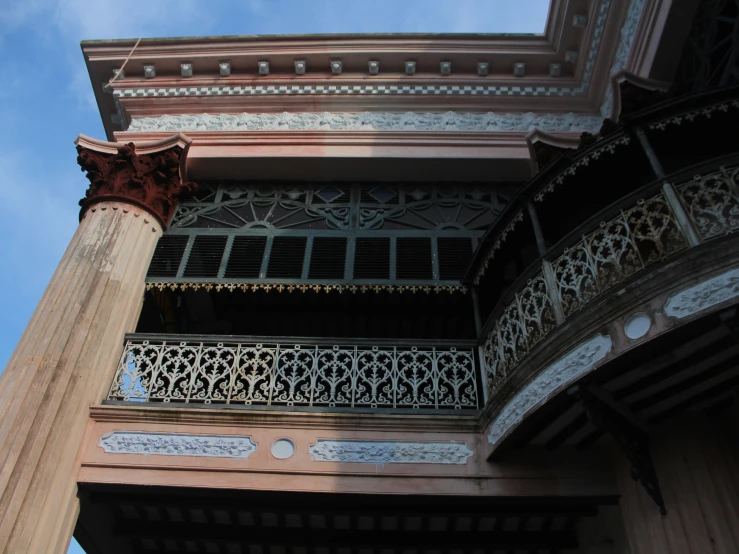 a view up the side of a building with balconies and metal railing