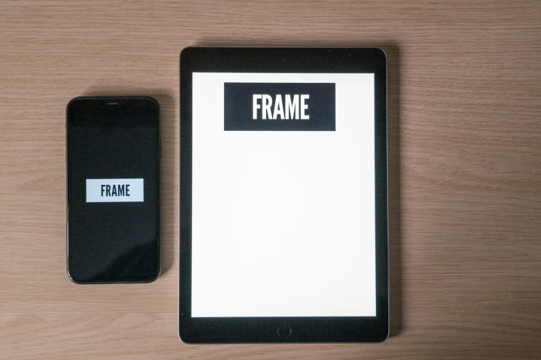 a black and white tablet and a small square item with a word frame on it