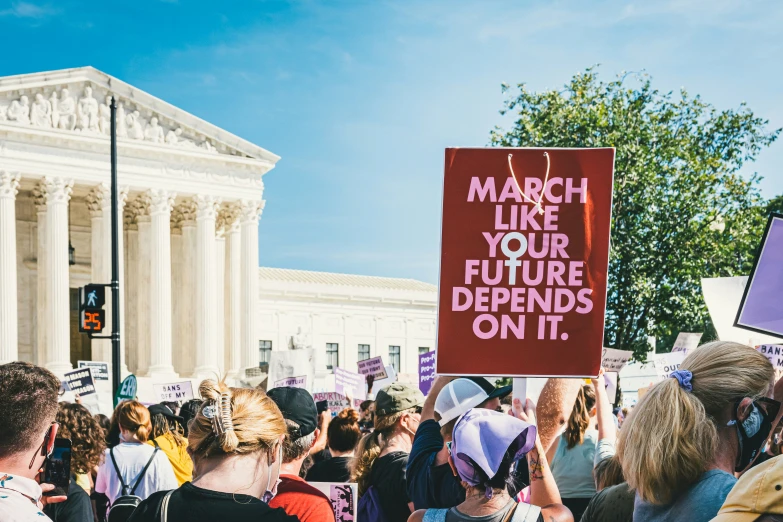 protestors march in front of the us supreme building in washington, dc