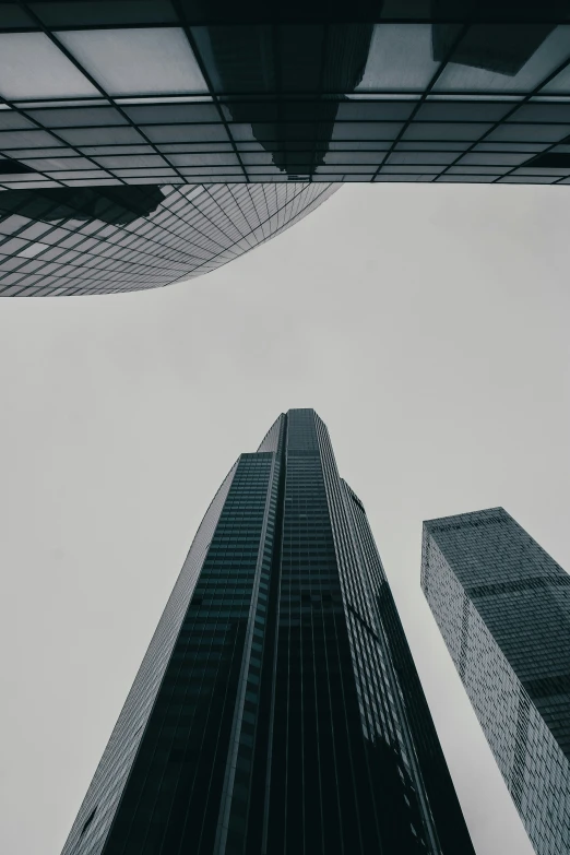 two tall building standing next to each other on a cloudy day