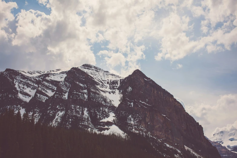 a mountain is covered in snow as the sky