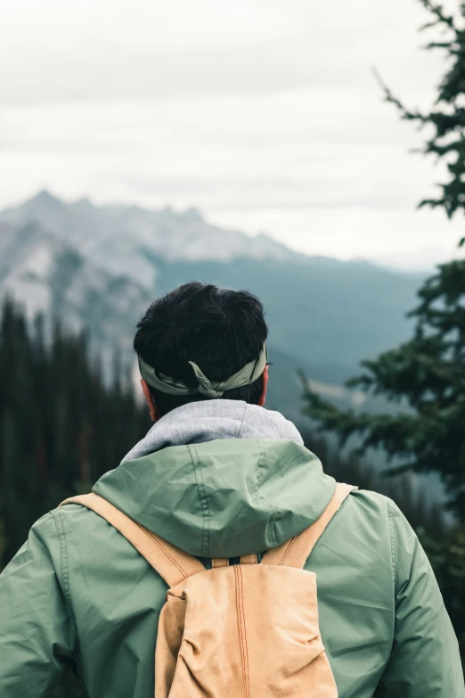 a man in the back with a backpack looks at the mountains