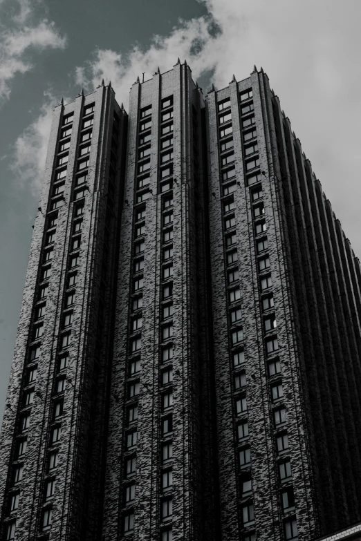 a very tall building sitting below a cloudy sky