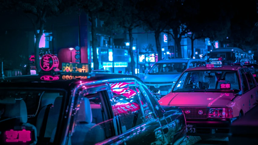 a street scene with many cars and people at night