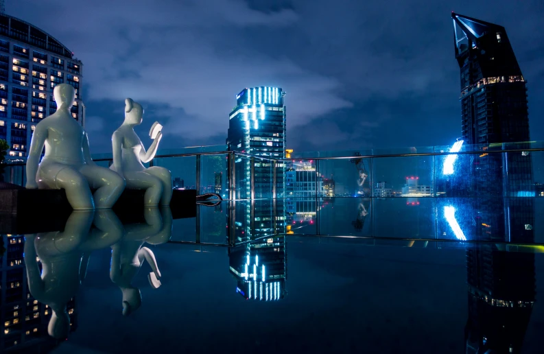 a sculpture on a roof in front of some buildings and water