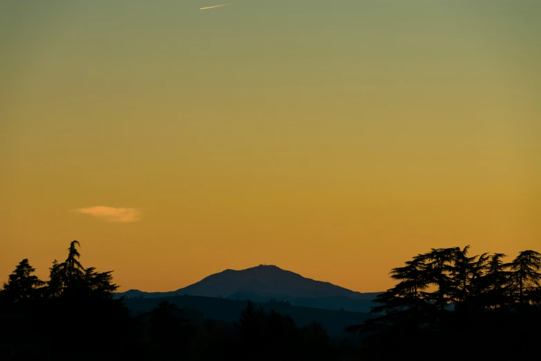 an airplane is flying high in the sky over trees