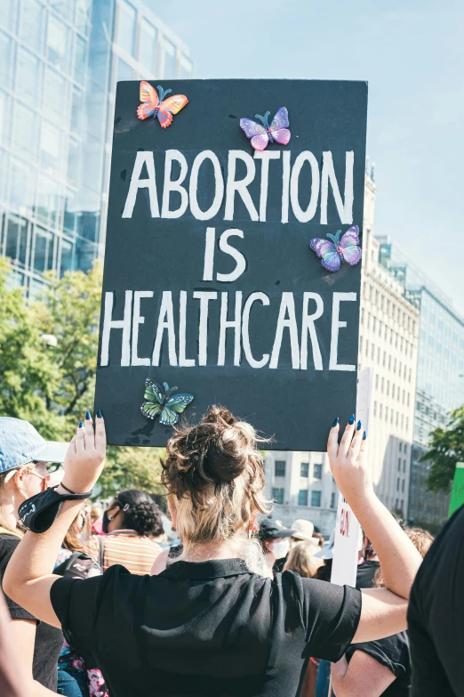 a person holding up a sign with erflies in it