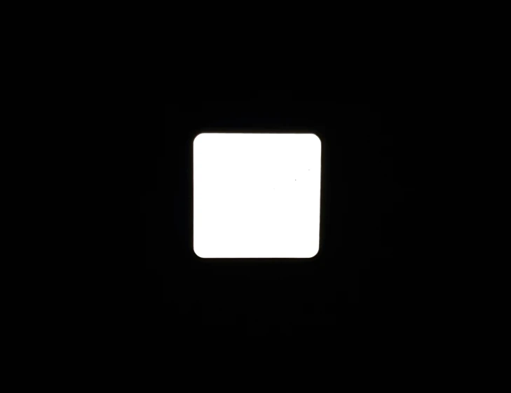 square object with white frame in dark room