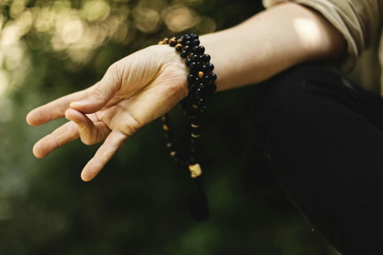 a person is showing their hand and some beads