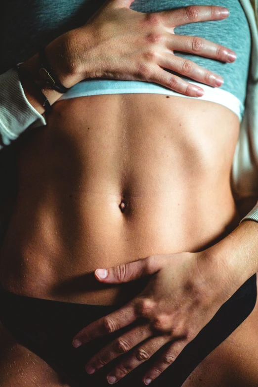 woman showing her toned stomach with hands over her 