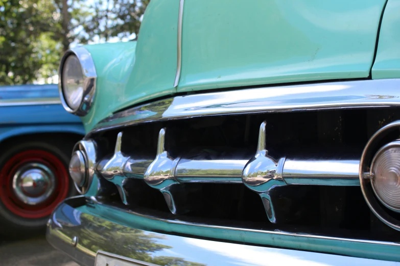 an old green car parked next to other classic cars