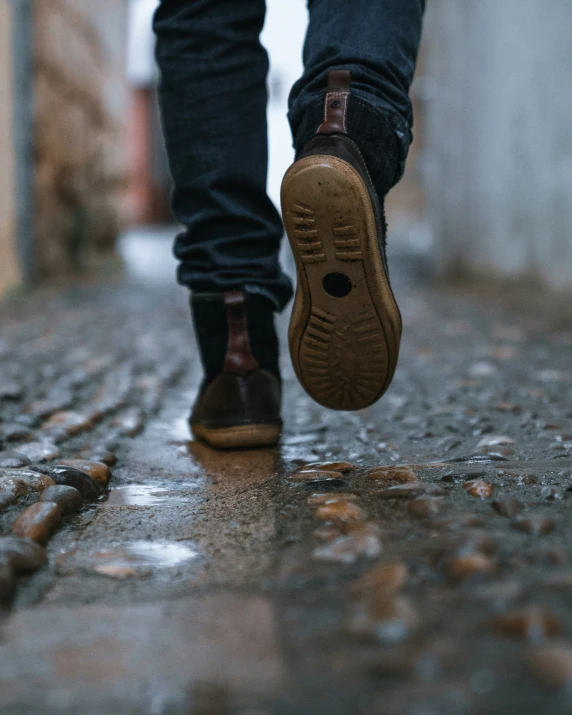 a person walking on the wet sidewalk