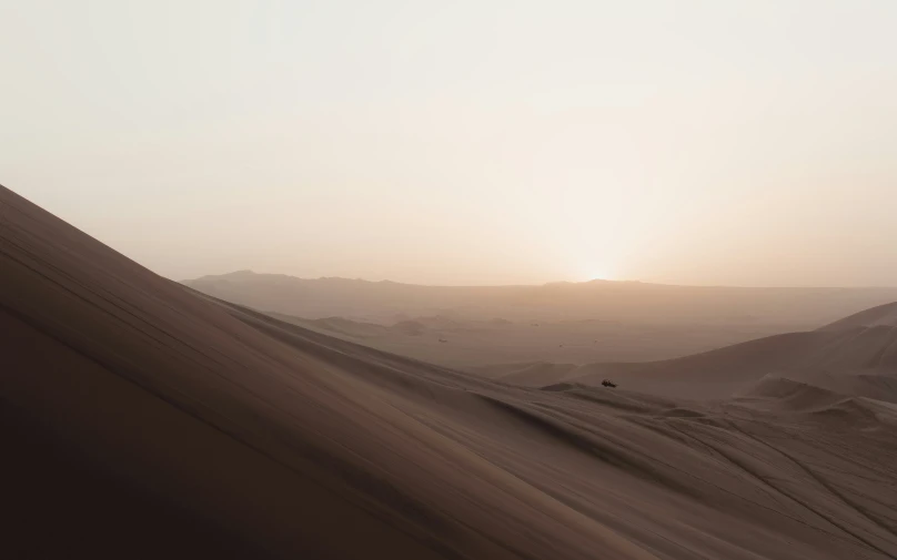 the sun rises over the sand dunes in the desert