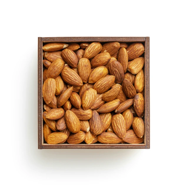 almonds in a wooden box on white background