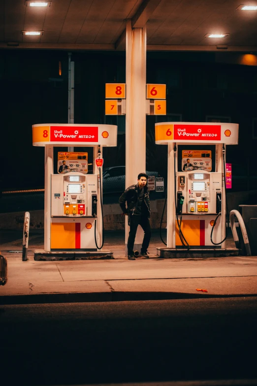 a man stands at the gas pumps for convenience