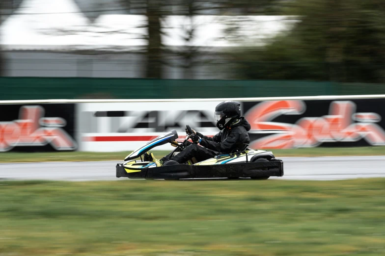 people racing a race track on a karting car