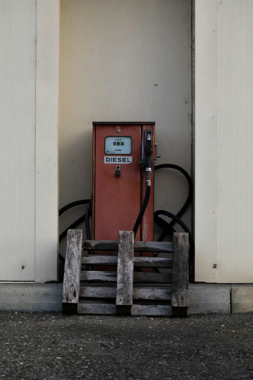 a telephone on a wooden bench and two other old phones in front of the wall