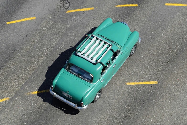 top view of a vintage car on road with yellow lines