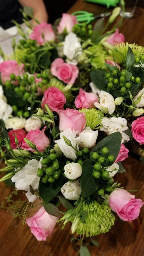 there are pink and white flowers arranged on a table