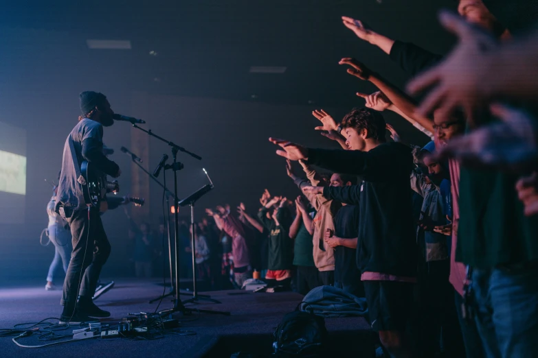 a crowd clapping and a man in the microphone