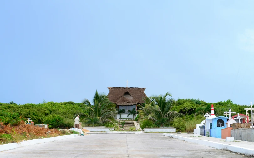 a small church with a thatched roof and crosses