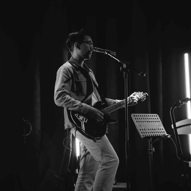 a black and white po of a man playing guitar